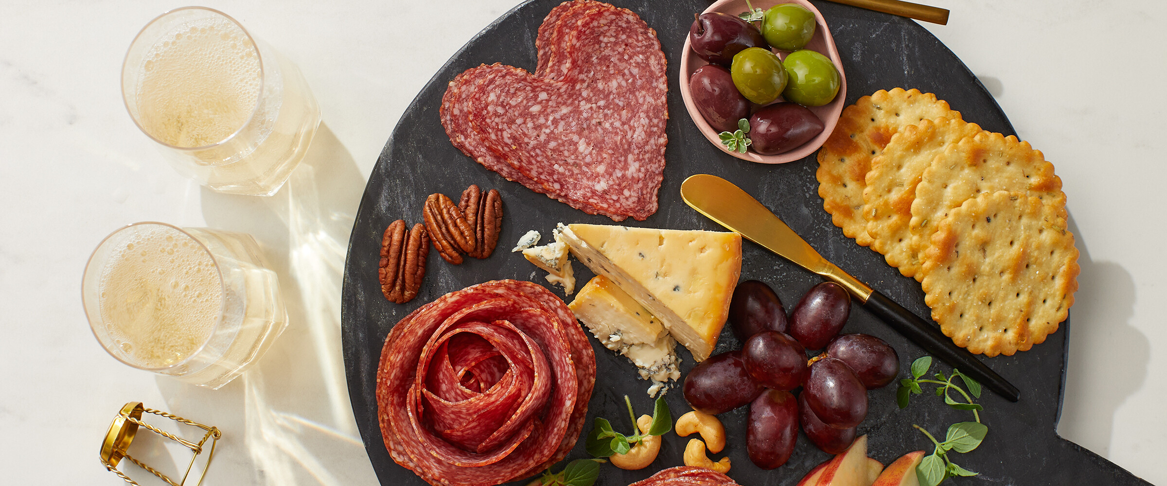 flower shaped sliced meat with cheese and figs on a board