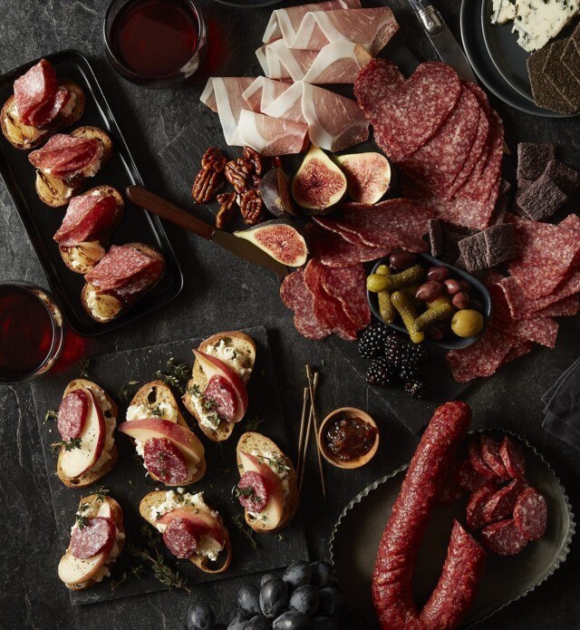 charcuterie meats, cheeses and fruits on a black slate