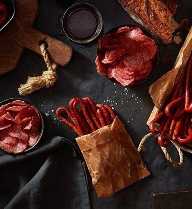Salami whips and chips on a black slate with parchment paper